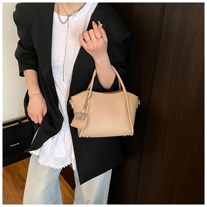 Detail of light khaki leather bucket bag with silver chain lock and twin handles