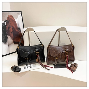 Detailed view of vintage saddle bags with distressed leather and woven tassel accents