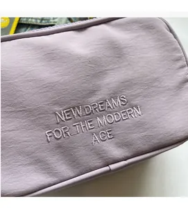 Detail of lavender canvas camera bag featuring modern age embroidery and fine stitching