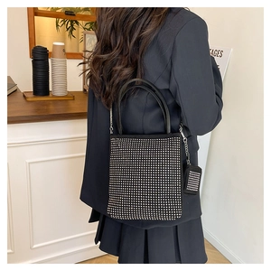 Détail d'un sac hobo noir en strass avec chaîne argentée et pendentif porte-monnaie mini