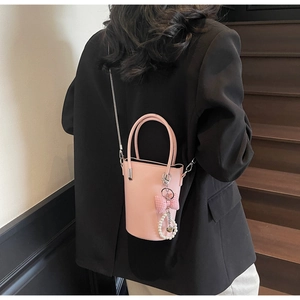 Detail der rosa Leder-Eimertasche mit silberner Kette und Perlen-Schleifen-Anhänger