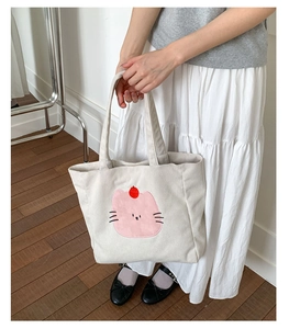 Détail du sac fourre-tout en velours côtelé blanc cassé avec applique de chat rose