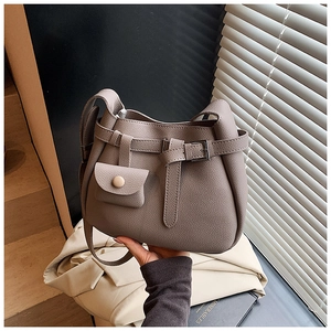 Detail of taupe litchi grain bucket bag featuring decorative buckle and mini coin purse