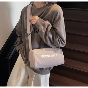 Detail of a large canvas pillow bag featuring wide shoulder straps and Moonlersa logo