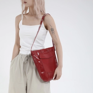 Borsa a secchiello retrò in pelle verniciata rossa con borchie indossata da modella