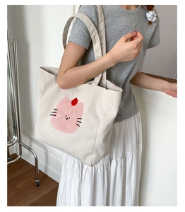 Détail du sac cabas en velours côtelé montrant la grande capacité et le motif chat