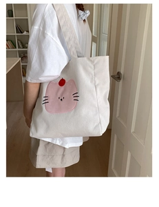 Détail de la broderie chat rose mignon sur un sac cabas en velours côtelé blanc rayé