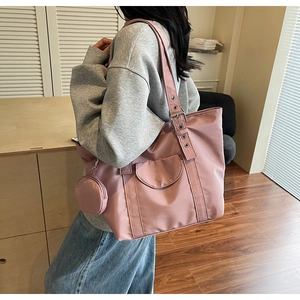 Pink nylon tote bag with adjustable metal eyelet strap and small round coin purse charm