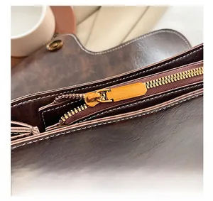 Detail view of the vintage bronze zipper and premium oil wax leather on a brown bag