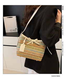 Detail of colorful woven shoulder bag featuring white leather trim and bow decoration