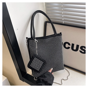 Détail du sac cabas noir orné de rivets argentés et d'une fine bandoulière en chaîne