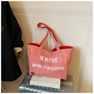 Detail of red vertical striped canvas tote bag with white MIRFNE letter print and metal logo