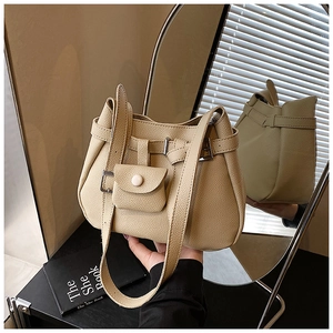 Detail of beige bucket bag featuring pebbled leather texture and mini snap coin purse