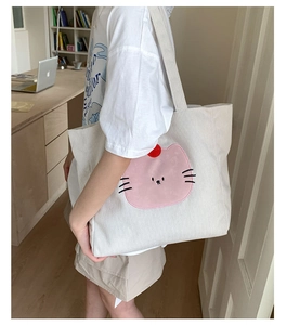 Détail du sac fourre-tout en velours côtelé blanc avec écusson chat rose et broderie