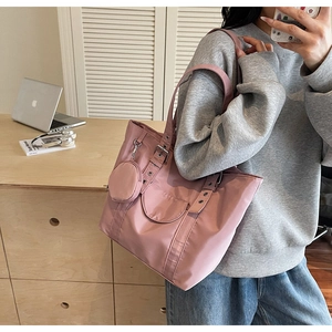 Pink nylon tote bag details showing the adjustable metal eyelet strap and mini purse