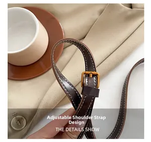 Detail of adjustable dark brown leather shoulder strap with vintage bronze buckle