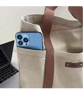 Detail of canvas tote bag with front pocket showing ample storage space for a phone