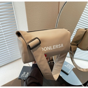 Detail of khaki canvas cylinder bag featuring DONLERSA logo and black adjustable strap