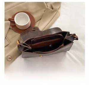 Macro view of retro brown shoulder bag interior featuring organized compartments and hardware