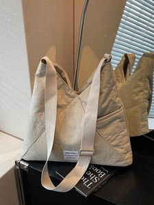 Minimalist beige oversized nylon crossbody bag with adjustable wide shoulder strap