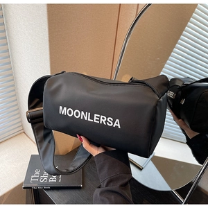Detailed shot of the black MOONLERSA canvas cylinder bag with a wide adjustable strap