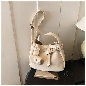 Close-up of cream pebble grain leather bucket bag with silver hardware and mini pouch