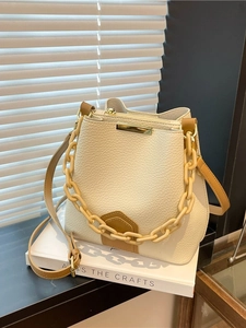 Sac seau beige en cuir grainé avec chaîne dorée et bandoulière marron réglable