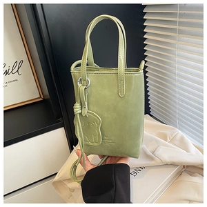 Detail of light green mini tote bag with BANTOR embossing and cute bear charm