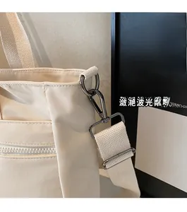Detail of premium beige tote bag showing durable metal D-ring and woven shoulder strap