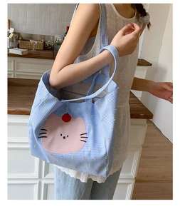 Détail du sac cabas en toile à carreaux bleus avec imprimé chat rose et grand intérieur