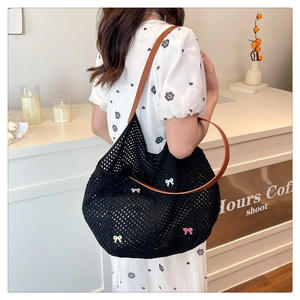 Black woven tote bag featuring colorful mini bows and brown leather shoulder straps