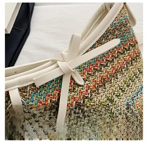 Detail of woven straw handbag featuring colorful patterns and white faux leather bow