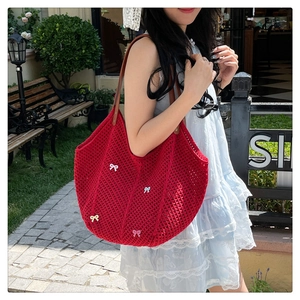 Detail of red crochet tote bag with colorful mini bows and brown leather straps