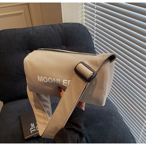 Detail view of the MOONLEE beige canvas barrel bag featuring a wide adjustable strap