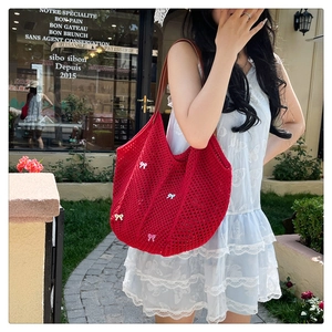 Detailed view of red crochet tote bag with colorful bows and brown leather straps