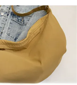 Close-up of khaki dumpling bag showing soft textured fabric and casual style