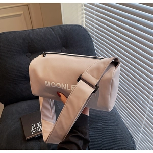 Detail of light pink canvas cylinder pillow bag with wide strap and zipper closure