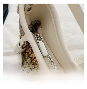 Macro detail of high-quality smooth metal zipper on textured woven crossbody bag