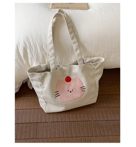 Détail du sac cabas en velours côtelé avec broderie chat rose et texture côtelée