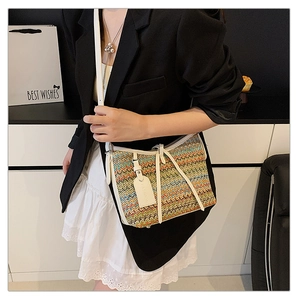 Fashionable woven crossbody bag with colorful wavy patterns and white leather trim on model