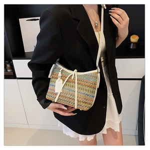 Macro shot of colorful woven texture and white leather trim on retro crossbody bag
