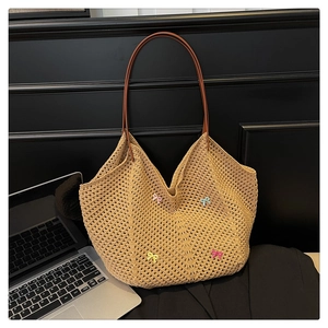 Detail of beige crochet tote bag with wave texture and colorful mini bow accents