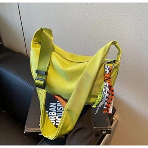 Detail of lime green nylon crescent bag with athletic woven pendants and NICE strap