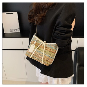Detail of colorful woven shoulder bag with white leather strap and bow decoration