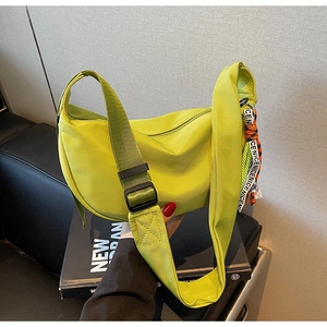 Detail of neon green nylon crescent bag featuring street style decorative brand ribbons