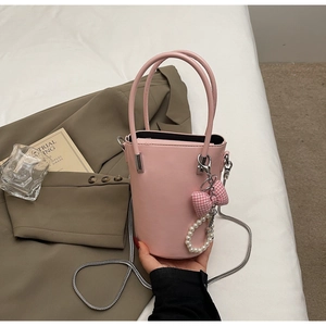 Detailansicht der hellrosa Beuteltasche mit Silberkette, Perlen und Schleifenanhänger