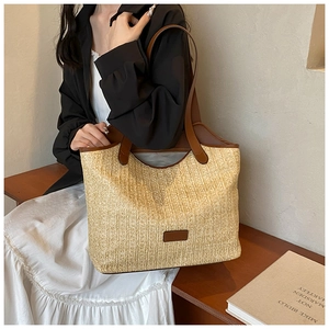 Straw tote bag with brown leather straps and spacious interior for summer travel