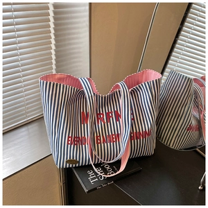 Close-up of blue and white striped canvas tote bag with pink lining and printed quote