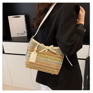 Detail of colorful woven shoulder bag with wavy patterns and chic white bow decoration