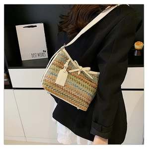 Detail of colorful woven shoulder bag with rainbow wave pattern and bow decoration